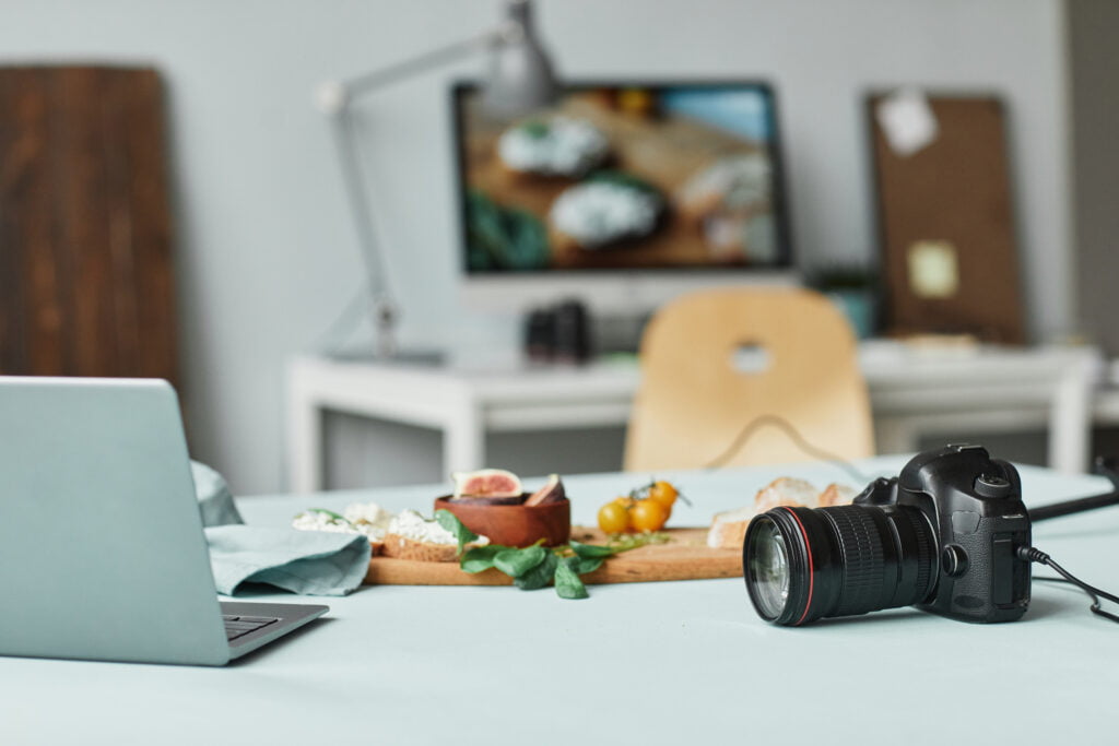 Background image of photographers studio with focus on camera and laptop