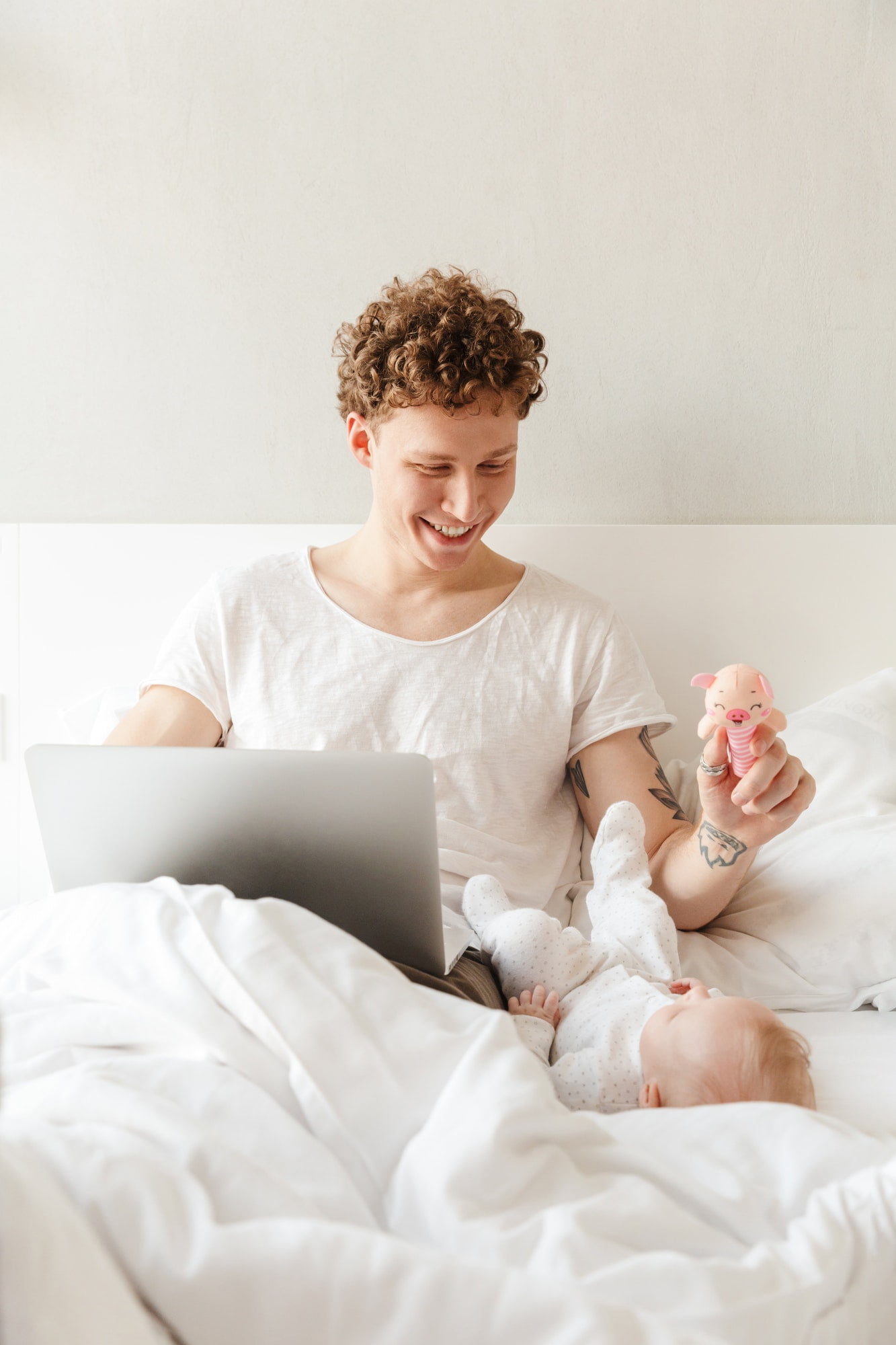 Happy young father playing with his little baby son